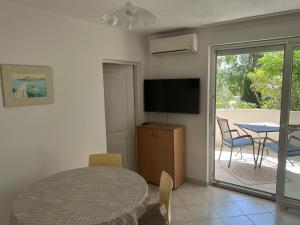 a bedroom with a bed and a television and a table at Apartments MiaMaja in Novalja