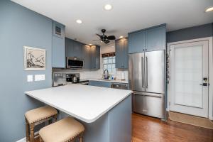 a kitchen with blue cabinets and a white counter top at Dreamy Downtown Condo, Near Meeting St & Broad St in Charleston