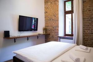 克卢日-纳波卡Contessa Central Studio的一间设有床铺和墙上电视的房间