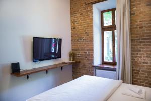 a bedroom with a bed and a television on a wall at Contessa Central Studio in Cluj-Napoca