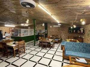 a restaurant with tables and chairs in a room at Gopika Resort in Vrindāvan