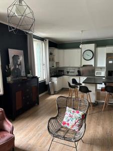 a living room with a chair and a kitchen at Madras in Sète