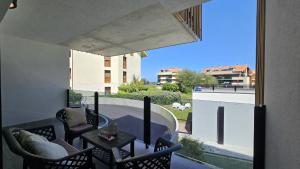 a balcony with chairs and a table and a large window at Apartamento Mar y Montaña in Barro de Llanes