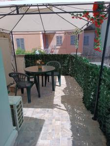 Un patio con una mesa y sillas bajo una sombrilla. en CORSO DEI CORSI, en Parma