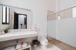a bathroom with a sink and a toilet and a mirror at La Catrina de Alcala in Oaxaca City