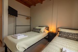 a small room with two beds and a tv at Habitación en Hospedaje Achalay, Qué lindo ! Qué bueno ! in Santa Fe