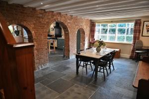 a dining room with a table and a brick wall at The Cider House at Stathe Farm in Burrowbridge +39 photos