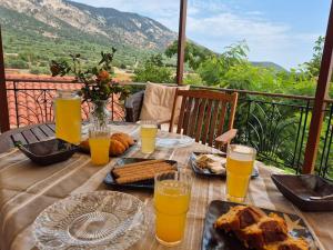 a wooden table with food and glasses of orange juice at Agrampeli Villa in Valsamáta