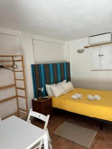 a bedroom with a yellow bed and a ladder at Vitória House in Évora