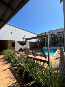 a patio with a bench and a swimming pool at Pousada da Praça in Ponte Alta do Tocantins