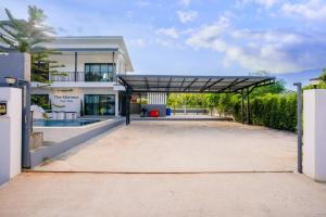 an empty parking lot in front of a building at The Moment Pool Villa Bangsaray in Bang Sare