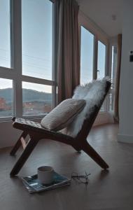 a bird seat in a living room with a window at Castelao 43 in Arcade