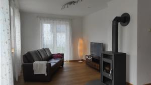 a living room with a couch and a fireplace at Zum Schmetterlingsflieder in Kettershausen