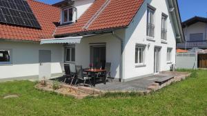 a patio with chairs and a table in front of a house at Zum Schmetterlingsflieder in Kettershausen