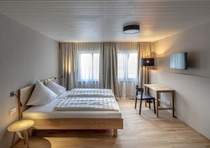 una camera d'albergo con un letto e una scrivania di Gasthof Löwen Tosters a Feldkirch