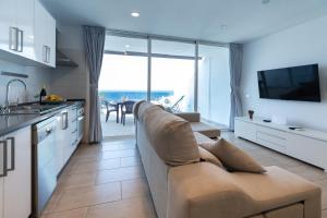 a kitchen and living room with a couch and a television at Bellavista in Tías