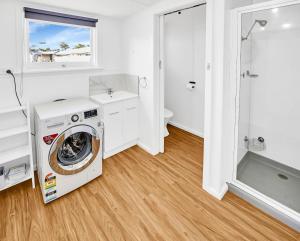 eine Waschküche mit Waschmaschine und Trockner in der Unterkunft Camellia Cottage on Church in Lakes Entrance
