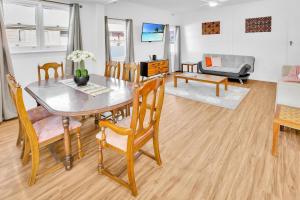 ein Esszimmer und ein Wohnzimmer mit Tisch und Stühlen in der Unterkunft Camellia Cottage on Church in Lakes Entrance