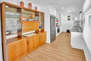 eine Küche mit Holzschränken und einer Arbeitsplatte in der Unterkunft Camellia Cottage on Church in Lakes Entrance + 10 Fotos