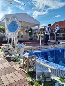 a clock next to a swimming pool with people at Pensiunea Axa Alex in Stăneşti