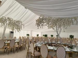 a white tent with tables and chairs and chandeliers at Pensiunea Axa Alex in Stăneşti