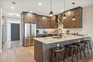 a kitchen with wooden cabinets and a large island with bar stools at Highlands of the Smokies 210 3br in Gatlinburg