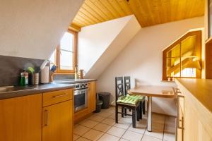 a kitchen with wooden cabinets and a table in a room at Ferienwohnung in ländlicher Lage in Meckenbeuren