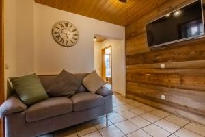 a living room with a couch and a clock on the wall at Ferienwohnung in ländlicher Lage in Meckenbeuren