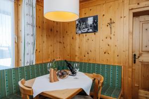 a dining room with a white table and wooden walls at Thurntaler Rast in Außervillgraten