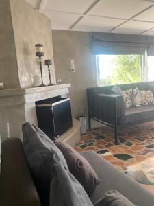 a living room with a couch and a fireplace at COTTAGE villa in Káto Panayía
