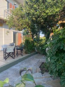 a patio with a table and chairs and a table and trees at COTTAGE villa in Káto Panayía