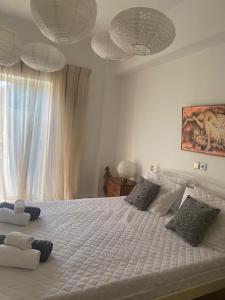 a bedroom with a large white bed with a window at COTTAGE villa in Káto Panayía