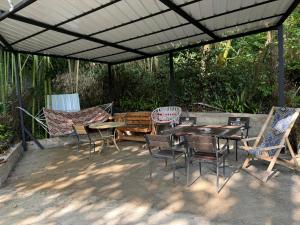 a patio with tables and chairs under a pergola at House in the Bamboos in Batumi