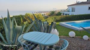 una mesa azul y sillas junto a una piscina en CASA DOMINO SOTOGRANDE Torreguadiaro, en Sotogrande 21 fotos más