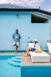a woman sitting on a chair next to a swimming pool at Blue Coco in Keramas