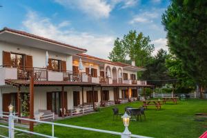 un edificio con un patio con sillas y mesas en Maria Village, en Vourvourou