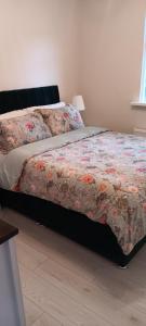 威克洛Stylish Comfortable的一间卧室配有一张带花卉棉被的床