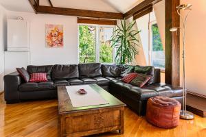 a living room with a black leather couch and a table at Pensiunea Casa Bono in Braşov