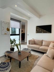 un salon avec un canapé et une table dans l'établissement DOI 45 Apartment, à Playa del Carmen