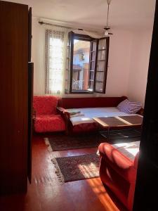 a living room with a red couch and a table at Aurora Stara kuća , 2km od Banje Ždrelo, selo Malo Laole in Malo Laole +2 photos