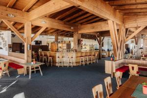 a restaurant with wooden ceilings and tables and chairs at Thurntaler Rast in Außervillgraten