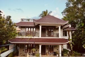 an old house with a red roof at Daffodils Inn in Alleppey