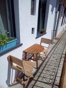 two benches and a table on the side of a building at Next Door Studio in Cluj-Napoca