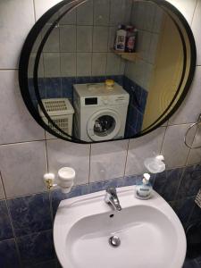 a bathroom sink with a mirror and a washing machine at EniGuesthouse in Gjirokastër +47 photos