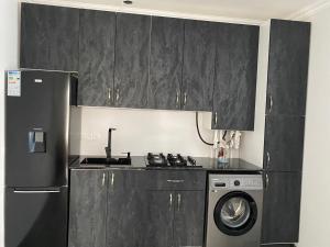 a kitchen with a refrigerator and a washing machine at Отдых в Ташире in Vorontsovka +15 photos