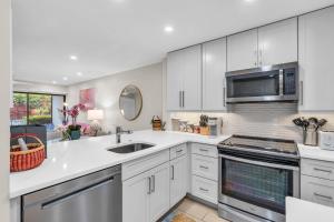 ネープルズにあるCompletely renovated first floor condoのシンクと電子レンジを備えた白いキッチン
