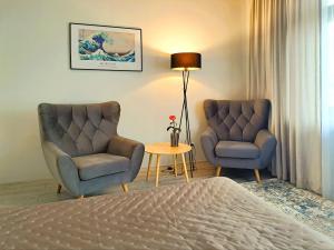 a bedroom with two chairs and a bed and a table at Tullu Apartament - w centrum, blisko bulwaru, blisko molo in Ostróda