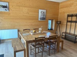 a dining room with a wooden table and chairs at O Nid Naturel in Mauléon