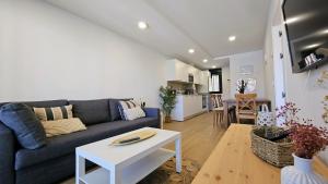 a living room with a blue couch and a white table at Apartamento Mar y Montaña in Barro de Llanes