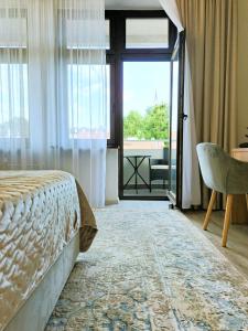 a bedroom with a bed and a view of a balcony at Tullu Apartament - w centrum, blisko bulwaru, blisko molo in Ostróda